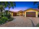 Stunning exterior of a yellow stucco home with a tile roof and a circular driveway lined with palm trees and manicured landscaping at 1931 Kentucky Ne Ave, St Petersburg, FL 33703