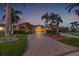 Inviting single story home featuring a tile roof, double door entryway and a brick driveway surrounded by palm trees at 1931 Kentucky Ne Ave, St Petersburg, FL 33703