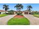 Inviting home with manicured lawn, tropical landscaping, and a brick driveway at 1931 Kentucky Ne Ave, St Petersburg, FL 33703