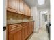 Laundry room with wood cabinets, light colored granite counters and tile backsplash with modern appliances at 1931 Kentucky Ne Ave, St Petersburg, FL 33703