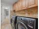 Modern laundry room with side by side washer and dryer and granite counters at 1931 Kentucky Ne Ave, St Petersburg, FL 33703