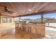View of a covered outdoor kitchen area with stone countertops and stainless steel appliances by the water at 1931 Kentucky Ne Ave, St Petersburg, FL 33703