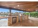 Exterior view of a covered outdoor kitchen area with stone countertops and stainless steel appliances by the water at 1931 Kentucky Ne Ave, St Petersburg, FL 33703