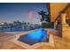 Beautiful pool and jacuzzi at dusk with adjacent outdoor kitchen overlooking the serene canal with waterfront views at 1931 Kentucky Ne Ave, St Petersburg, FL 33703