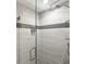 Walk-in shower features gray tiles and a glass door, creating a modern and luxurious experience at 1931 Kentucky Ne Ave, St Petersburg, FL 33703