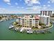 A stunning aerial view of a waterfront condo with boat slips, pool, and bay views on a sunny day at 200 Skiff Pt # 202, Clearwater Beach, FL 33767