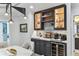 Elegant bar area featuring custom cabinetry, stone countertops, wine storage, and recessed lighting at 200 Skiff Pt # 202, Clearwater Beach, FL 33767