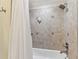 The bathroom features tiled walls with a tub, a shower head, and built-in shelves for storage and convenience at 200 Skiff Pt # 202, Clearwater Beach, FL 33767