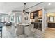 Dining area with modern light fixture, four chairs and beverage center, integrated into open concept kitchen and living room at 200 Skiff Pt # 202, Clearwater Beach, FL 33767