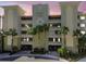Majestic Point condos exterior featuring a neutral facade, tropical landscaping, and secure gated entrances at 200 Skiff Pt # 202, Clearwater Beach, FL 33767