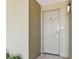 Exterior view of a neutral-colored front door with a modern keypad lock, set in a stucco facade with outdoor lighting at 200 Skiff Pt # 202, Clearwater Beach, FL 33767