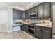 Modern kitchen features gray cabinets, stainless steel appliances, and stylish backsplash at 200 Skiff Pt # 202, Clearwater Beach, FL 33767