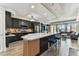 Spacious kitchen with a large island, barstool seating, dark cabinets, and stainless steel appliances in an open layout at 200 Skiff Pt # 202, Clearwater Beach, FL 33767