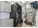 Gray cabinets flank a front loading washer/dryer and utility area with neutral flooring and storage at 200 Skiff Pt # 202, Clearwater Beach, FL 33767