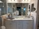 Bright bathroom with dual sinks, white cabinets, and large framed mirror at 20938 Sunsweet Ct, Land O Lakes, FL 34637