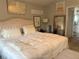 Elegant main bedroom with tufted headboard, soft bedding, and ensuite bathroom access at 20938 Sunsweet Ct, Land O Lakes, FL 34637