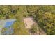 Aerial view of community sand volleyball court, next to the lush canopy of trees, and tennis courts at 2124 Rensselaer Dr, Wesley Chapel, FL 33543