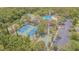 Aerial view showcasing community amenities, including tennis courts, a pool, and ample parking at 2124 Rensselaer Dr, Wesley Chapel, FL 33543