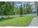 Lush backyard with mature trees and pristine landscaping, providing a private and serene outdoor oasis at 2124 Rensselaer Dr, Wesley Chapel, FL 33543