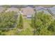 Aerial view of a backyard with a partial lanai, mature trees, manicured lawn and full privacy fence at 2124 Rensselaer Dr, Wesley Chapel, FL 33543