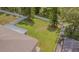 Aerial view showcasing a spacious backyard with mature trees, white fence, and covered patio at 2124 Rensselaer Dr, Wesley Chapel, FL 33543