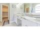 Bathroom with dual sinks, granite countertops, and a walk-in closet at 2124 Rensselaer Dr, Wesley Chapel, FL 33543