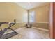 Cozy bedroom with neutral walls, tile flooring, natural light, and minimal furnishings at 2124 Rensselaer Dr, Wesley Chapel, FL 33543
