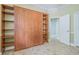 Neutral bedroom featuring a murphy bed with side shelving and tiled floors at 2124 Rensselaer Dr, Wesley Chapel, FL 33543