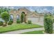 Inviting two-story home with well-maintained lawn and garden beds, and an attached three-car garage at 2124 Rensselaer Dr, Wesley Chapel, FL 33543
