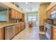 Well-lit kitchen featuring tile floors, wooden cabinets, granite countertops and stainless steel appliances at 2124 Rensselaer Dr, Wesley Chapel, FL 33543