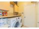 Clean laundry room with modern washer and dryer, storage cabinets, and granite countertops at 2124 Rensselaer Dr, Wesley Chapel, FL 33543