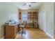 Home office featuring built-in shelving, laminate flooring, and a neutral color palette at 2124 Rensselaer Dr, Wesley Chapel, FL 33543