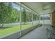 Relaxing screened lanai overlooking the lush green backyard with a white fence creating a serene outdoor space at 2124 Rensselaer Dr, Wesley Chapel, FL 33543
