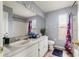 Neutral bathroom featuring a large mirror, vanity, toilet, and a tub with a patterned shower curtain at 2318 Kenwick Dr, Valrico, FL 33596