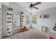 Bright bedroom with natural light, a ceiling fan, and stylish shelves for comfortable living at 2318 Kenwick Dr, Valrico, FL 33596