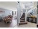 Bright foyer with a white staircase, unique decorative items, and an open view to the dining and living room at 2318 Kenwick Dr, Valrico, FL 33596