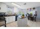 Bright kitchen with granite countertops, white cabinets, an island, and an adjacent dining area with outdoor views at 2318 Kenwick Dr, Valrico, FL 33596