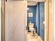 Powder room with a sliding door and blue accent wall at 284 North St, Palm Harbor, FL 34683