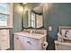Charming bathroom with double sink vanity, teal walls, framed art and modern lighting at 284 North St, Palm Harbor, FL 34683