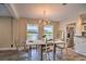 Bright dining area with chandelier, set table, and view to the kitchen and outdoors at 284 North St, Palm Harbor, FL 34683