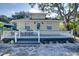 Charming yellow home featuring a cozy front porch with white picket fence and gray deck at 284 North St, Palm Harbor, FL 34683