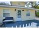 Close up front view of the porch with a love seat and an inviting front door with a wreath at 284 North St, Palm Harbor, FL 34683