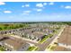 Wide aerial view of a neighborhood with gray townhomes and plenty of green space at 2925 Evergreen Elm Pass, Wesley Chapel, FL 33543