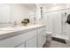 Well-lit bathroom featuring dual sinks, white cabinetry, and a walk-in shower with a shower curtain at 2925 Evergreen Elm Pass, Wesley Chapel, FL 33543