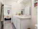 Clean bathroom with double vanity, large mirror, and doorway to the adjacent bedroom at 2925 Evergreen Elm Pass, Wesley Chapel, FL 33543