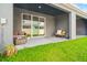 A cozy, covered patio area with comfortable seating overlooking the lawn at 2925 Evergreen Elm Pass, Wesley Chapel, FL 33543