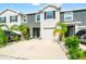 Two-story townhome featuring a one-car garage, manicured landscaping, and a concrete driveway at 2925 Evergreen Elm Pass, Wesley Chapel, FL 33543