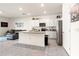 Open kitchen with stainless steel appliances, island, and white cabinets at 2925 Evergreen Elm Pass, Wesley Chapel, FL 33543
