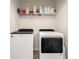 Efficient laundry room featuring a modern washer and dryer with storage shelf above at 2925 Evergreen Elm Pass, Wesley Chapel, FL 33543