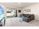Cozy living room with tile flooring, sectional couch, and sliding glass doors to the backyard at 2925 Evergreen Elm Pass, Wesley Chapel, FL 33543